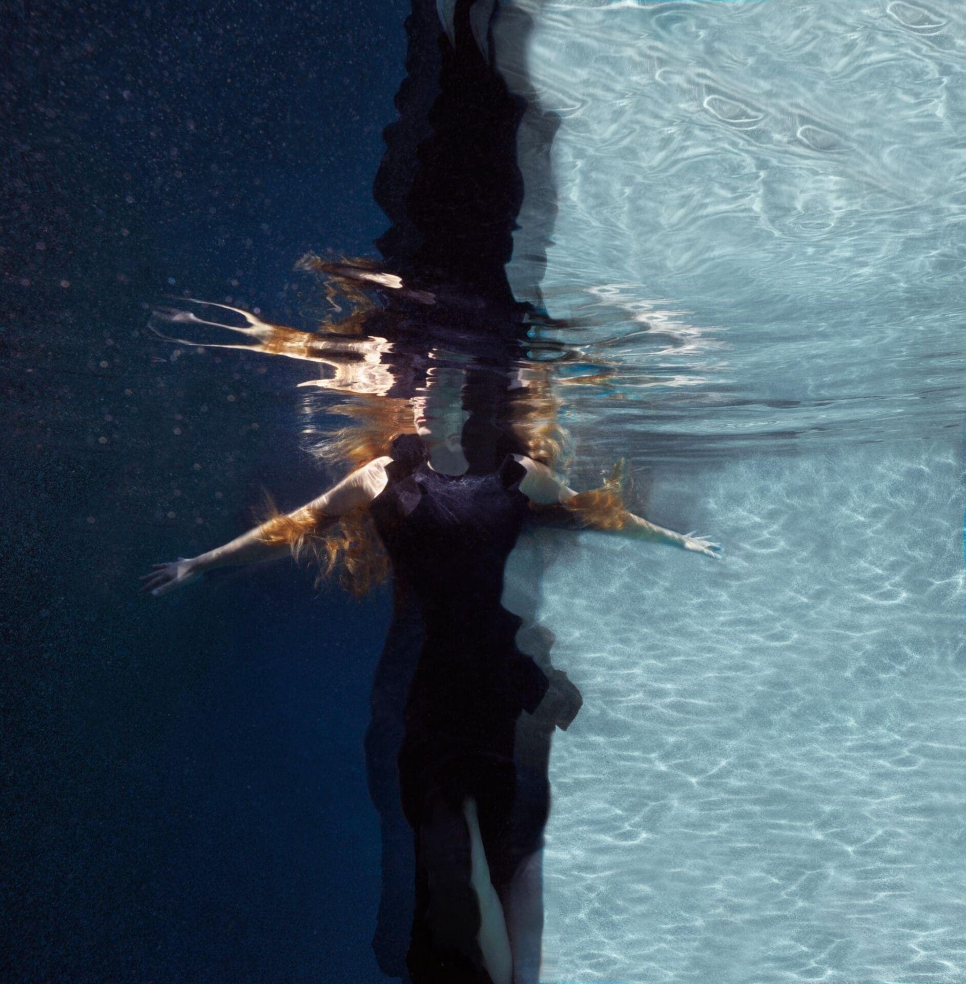 a person in a black dress underwater